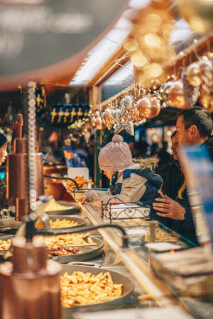 Salzburg, Austria - December 2018: Children enjoying the Salzburg Christmas Market at a street food standのeditorial素材