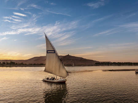 Tourist taking a ride in a Felucca boat in Luxor Egypt on the NIle Riverの写真素材