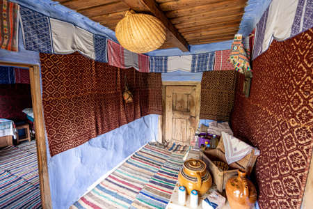 Corbi, Romania - July 2019: traditional peasants house interior well preserved with authentic carpets, clothing and personal items insideのeditorial素材