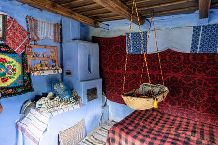 Corbi, Romania - July 2019: traditional peasants house interior well preserved with authentic carpets, clothing and personal items insideのeditorial素材