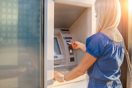 Young woman withdrawing money from credit card at ATM machineの写真素材