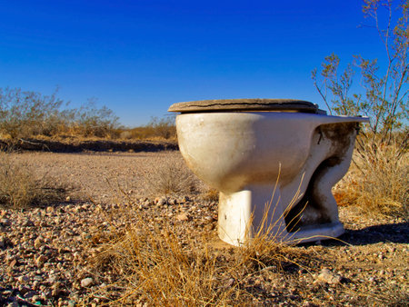 An old toilet abandoned in a remote area of the Arizona Desert.の写真素材