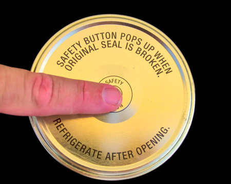 A metal lid for a food storage jar with a safety warning label.の写真素材