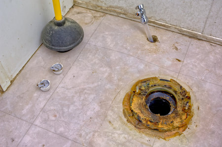 The melted remains of a wax ring seal that is beneath most toilet bowls. In this case the toilet bowl was removed to inspect for flood damage after the original feeder valve leaked and flooded the bathroom floor. When the bowl was removed it was revealed that the wax ring seal had virtually melted away from years of hot Arizona summers in a house with no air conditioning. These wax rings can melt if the home temperatures exceed 100*F. Once melted the seal is broken and the toilet can also leak when flushed.の写真素材