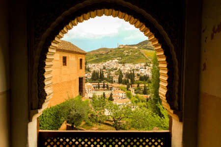 View from a window facing the downtown of Granada city. Arch windows of arabic origins and city architecture of arabic influence. Moors.のeditorial素材