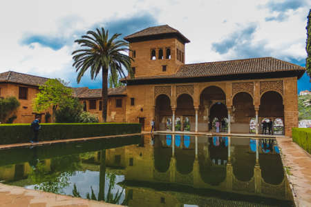 Granada, Spain - 5/6/18: Building of moorish architecture, with a pond / lake, beautiful columns and details. Torre de las Damas. El partal.のeditorial素材