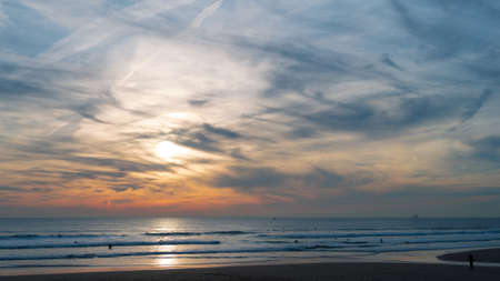 Carcavelos beach, one of the most famous Lisbon beaches, at sunset during winter, with many surfers in the water. Medium Waves.の写真素材