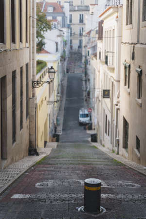 Long and narrow street in chiado Lisbon, Portugal. Elevation, ramp, hill going up and down. Slope with steep inclination. Stop written on the road.の写真素材
