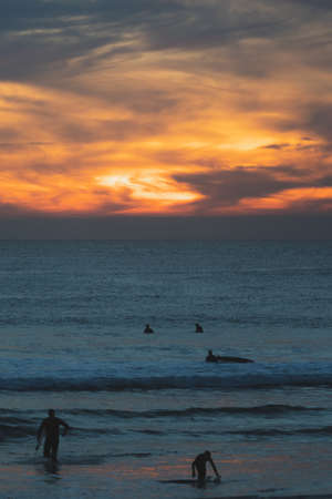 Carcavelos beach, one of the most famous Lisbon beaches, at sunset during winter, with many surfers in the water. Medium Waves.の写真素材
