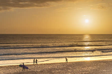 Carcavelos beach, one of the most famous Lisbon beaches, at sunset during winter, with many surfers in the water. Medium Waves.の写真素材