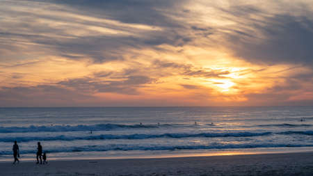 Carcavelos beach, one of the most famous Lisbon beaches, at sunset during winter, with many surfers in the water. Medium Waves.の写真素材