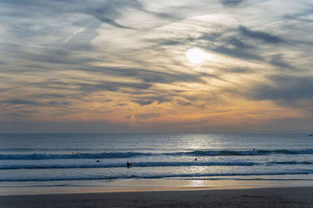 Carcavelos beach, one of the most famous Lisbon beaches, at sunset during winter, with many surfers in the water. Medium Waves.の写真素材