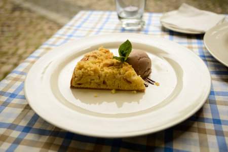 Prague piece of apple cake with ice cream on white plate の写真素材