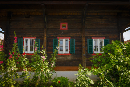 Front of old wooden house with windows with green shutters,Styria,Austria のeditorial素材