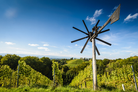 Styrian Tuscany Vineyard with windmill -klapotetz in foreground, Austriaの写真素材