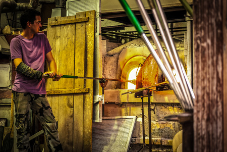 MURANO,ITALY-OCTOBER,09:Glassblowing artisan at work in a crystal glass workshop in Murano on October 09, 2012.Murano glassmakers use the same tools as their ancestors have thousands of years ago.のeditorial素材