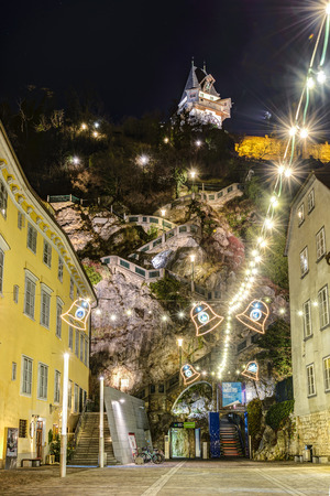 GRAZ, AUSTRIA - DECEMBER 24, 2015: The Clock Tower Uhrturm he Schossberg fortress and christmas decorated street in Graz, Austria.Old town of Graz is the UNESCO World Heritage.のeditorial素材