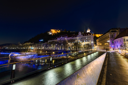 GRAZ, AUSTRIA - DECEMBER 24, 2015: Wall with Murinsel river, castle and clock tower Uhrturm he Schossberg in Graz, Austria.Old town of Graz is the UNESCO World Heritage.のeditorial素材