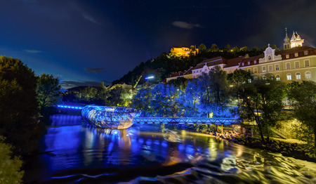 GRAZ, AUSTRIA - JULI 17, 2017: Mur river with Murinsel ,castle and Clock Tower Uhrturm on Schossberg in Graz, Austria.Old town of Graz is the UNESCO World heritage.のeditorial素材