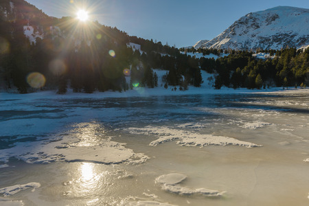 Landscape with a frozen lake in a mountain valley in winter sunny day, Styrian Alps, Austria.の写真素材