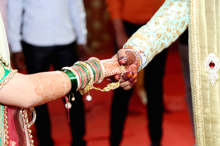 Indian traditional wedding couple hands together momentsの写真素材