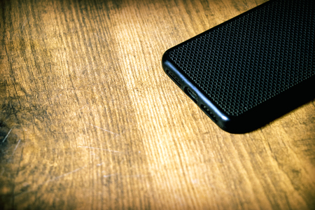 Blank screen mobile phone on a brown wooden board background with copy spaceの写真素材
