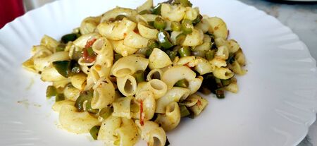Elbow macaroni pasta with tomatoes, beans and parmesan on a plate close-up on the table. Horizontalの写真素材