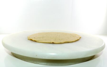Rolling wheat flour dough into round dumplings to make puri or chapati, an Indian breadの写真素材