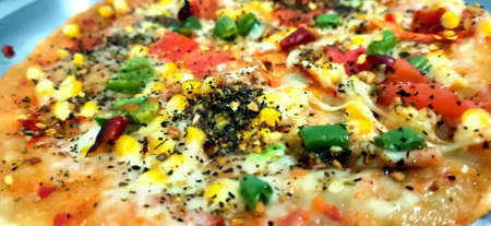 Tasty homemade Italian fresh delicious pizza with tomato & capsicum with cheeseの写真素材