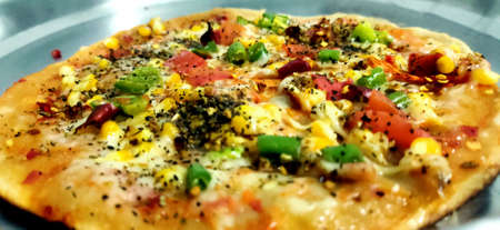 Tasty homemade Italian fresh delicious pizza with tomato & capsicum with cheeseの写真素材
