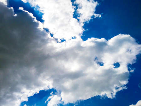 Bright blue sky background with cloudsの写真素材