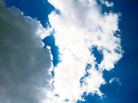 Bright blue sky background with cloudsの写真素材