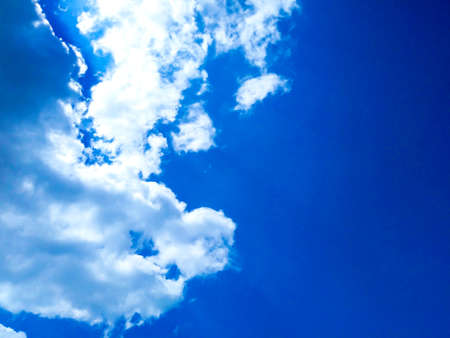 Bright blue sky background with cloudsの写真素材