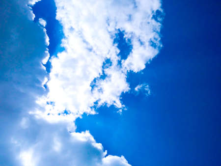 Bright blue sky background with cloudsの写真素材