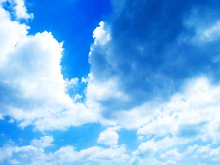 Bright blue sky background with cloudsの写真素材