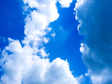 Bright blue sky background with cloudsの写真素材