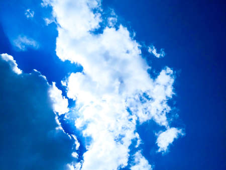 Bright blue sky background with cloudsの写真素材