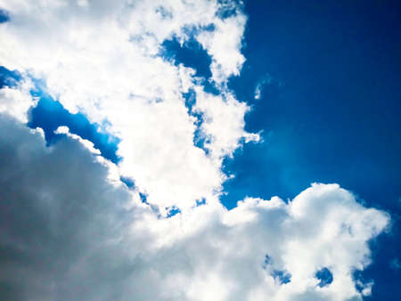 Bright blue sky background with cloudsの写真素材