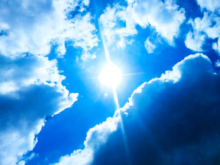 Sunny background, blue sky with white clouds and sunの写真素材