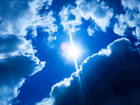 Sunny background, blue sky with white clouds and sunの写真素材