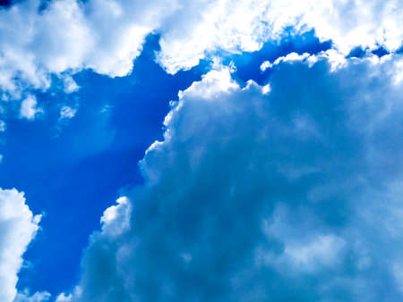 Bright blue sky background with cloudsの写真素材