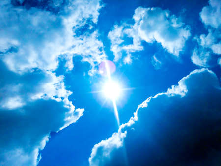 Sunny background, blue sky with white clouds and sunの写真素材