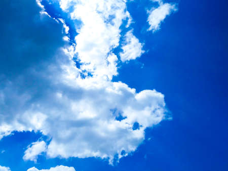 Bright blue sky background with cloudsの写真素材