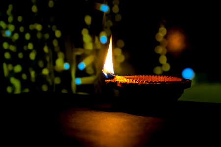 Happy Diwali. Clay diya candle illuminated in Dipavali, Hindu festival of lights. Traditional oil lamp on dark backgroundの写真素材