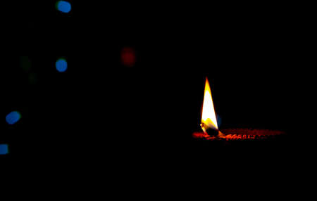 Diwali, Hindu festival of lights. Clay diya candle illuminated in Deepawali. Traditional oil lamp on dark background, copy space.の写真素材