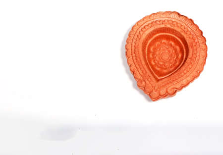 A close up of a beautifully designer handmade clay lamp isolated on white background for diwali...