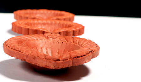 A close up of a beautifully designer handmade clay lamp isolated on white background for diwali festivalの写真素材