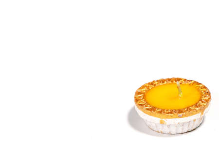 A close-up of a yellow candle on white backgroundの写真素材