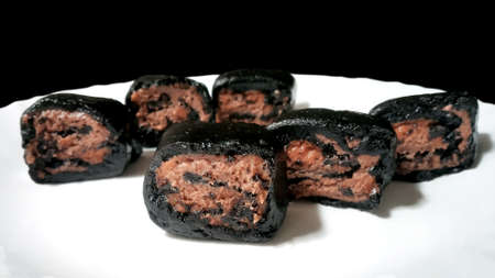 Creamy cake pieces with chocolate cookies and cream biscuits in a white plate