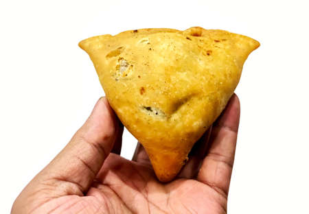 A man holding fried samosa in hand isolated on white backgroundの写真素材